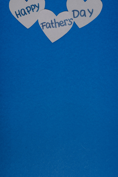 widok z góry szary papier rzemieślnicze serca z liternictwem szczęśliwy dzień ojców na niebieskim tle - Zdjęcie, obraz