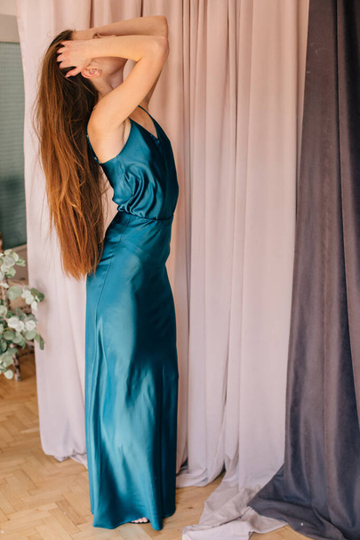 dívka s dlouhými blond vlasy tance svůdný tanec v modrých hedvábných šatech - Fotografie, Obrázek