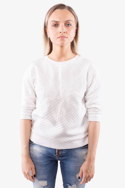 Young woman standing straight and looking directly at camera. White background - Photo, Image