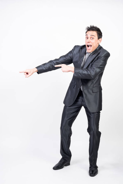 Smiling man in suit pointing to copy space. White background, full body - Φωτογραφία, εικόνα