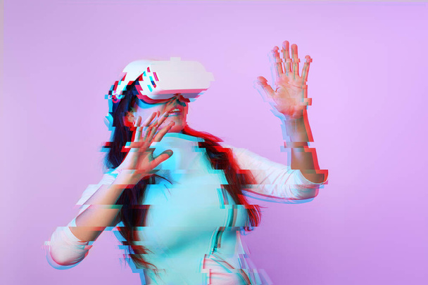 Vrouw gebruikt virtual reality headset. Afbeelding met glitch effect. - Foto, afbeelding