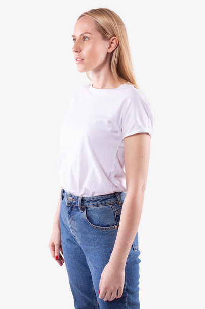 Young caucasian blond woman in casual wear stands half-sides, looks ahead - Photo, Image