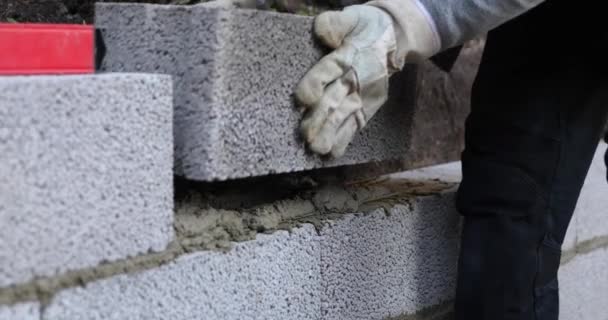 muratore che lavora con blocchi di calcestruzzo ceramsite, muro di sostegno edificio
 - Filmati, video