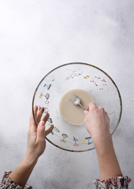 The process of cooking with hands. Preparation. Transparent bowl with yeast and water on a white background. Top view. Kitchen. Culinary. Background image, copy space - Foto, Imagem