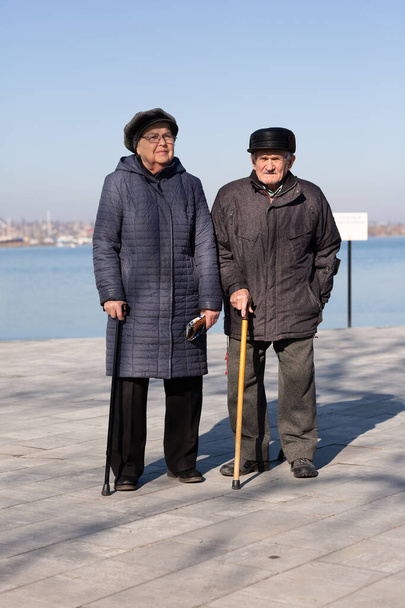 Kış günü gezinti güvertesinde yürüyen yaşlı çift. - Fotoğraf, Görsel