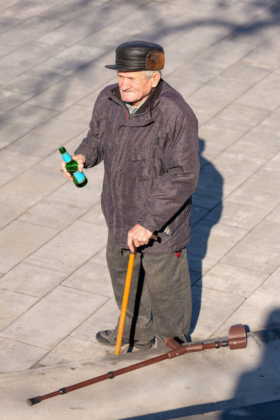 Homem idoso com uma garrafa de cerveja em uma caminhada
. - Foto, Imagem