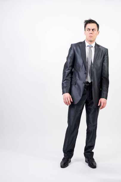 Distrustful man in suit. White background. Full body - Photo, image