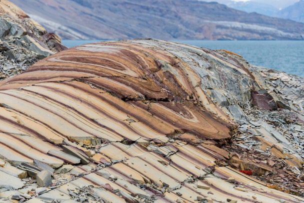 Doğu Grönland 'daki renkli kayalar kapanıyor. Kaya dokusu. - Fotoğraf, Görsel