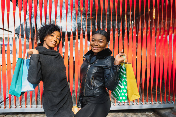 Closeup of Two Smiling Nice Black Girls Shopping - 写真・画像