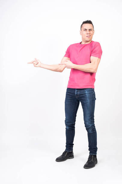 Surprised man pointing to copy space. White background, full body - Фото, изображение