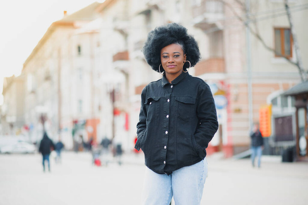 Beautiful girl with afro haircut walking on the street - Photo, image