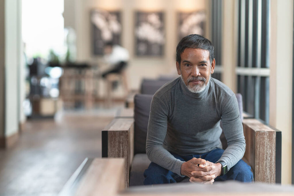 Portrait of happy mature man with white stylish short beard looking at camera. Casual lifestyle of retired hispanic people or adult asian man smile with confident sitting at modern coffee shop cafe. - Photo, Image