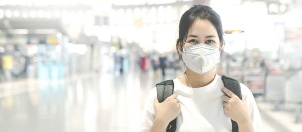 Banner de mujer asiática con marca facial saludable proteger el virus corona con fondo terminal del aeropuerto. El brote de coronavirus es enfermedad 2019 (COVID-19) se ha extendido al mundo
. - Foto, Imagen