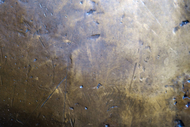 De textuur van de oude gele bronzen achtergrond is bedekt met een patina. - Foto, afbeelding