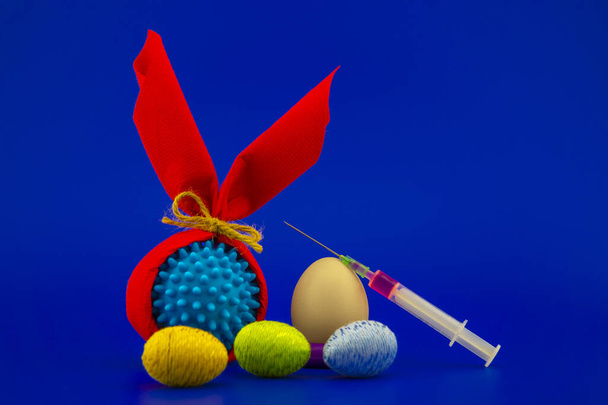 Corona virus models wrapped as gifts and Easter eggs on a blue background with copy space - Photo, Image