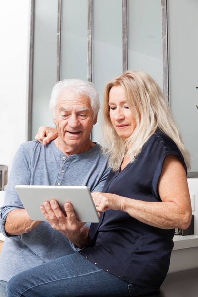 anziani coppia guardando un computer tablet
 - Foto, immagini