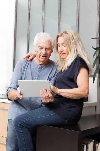 ηλικιωμένο ζευγάρι που κοιτάζει έναν υπολογιστή tablet - Φωτογραφία, εικόνα