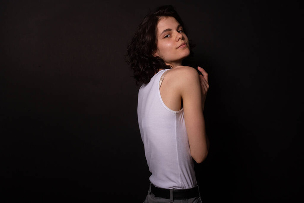 Young woman posing for photoshoot playfully looking. Isolated, black background - Foto, immagini