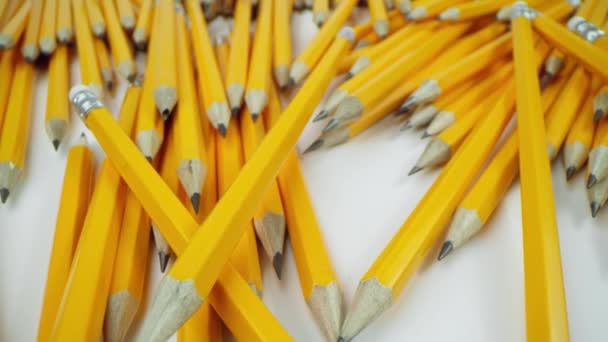 Sárga ceruzák feküdnek kaotikusan fehér háttér, makró lövés a laowa 24 mm - Felvétel, videó