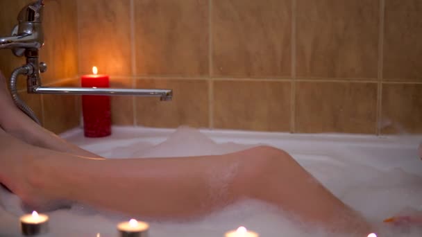 Young woman relaxing in babble bath, long legs, playing with foam, romantic - Felvétel, videó