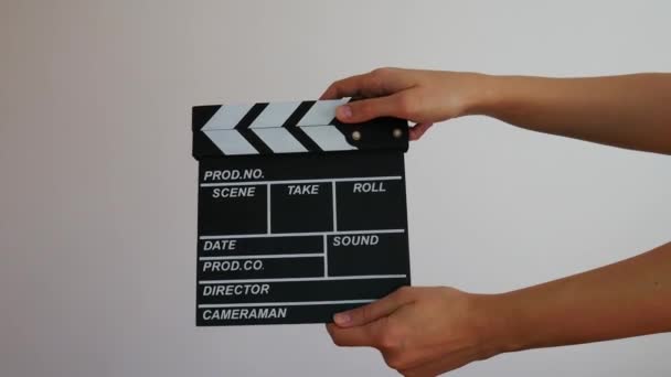 Close up female hold in hand wooden black clapperboard isolated on gray background. Cinematography production concept. Copy space advertising mock up.  - Footage, Video