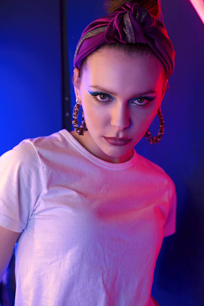 Portrait of a beautiful girl with colored lighting. Red and blue lights. - Foto, imagen