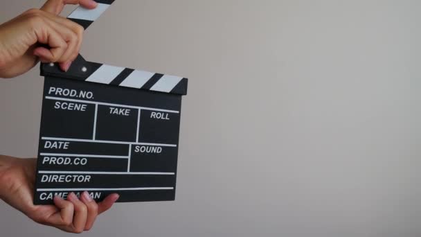 Close up female hold in hand wooden director clear empty black film making clapperboard isolated on gray background. Cinematography production concept. Copy space advertising mock up. Three different positions and three clappers. - Footage, Video