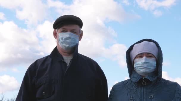 Idős férfi és nő kint, orvosi maszkban. Koronavírus világjárvány Idősek női és férfi viselnek védő maszkot az utcán. egészségügyi koncepció, az N1H1 koronavírus karantén, vírusvédelem. - Felvétel, videó