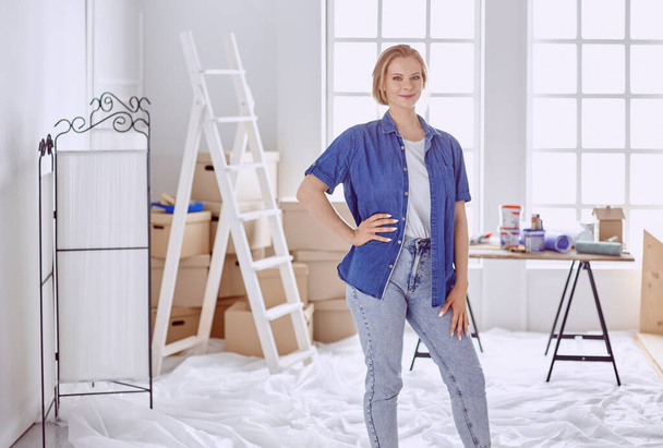 白い木製の階段で美しい若い女性。部屋を修復する準備ができています。女性家事概念 - 写真・画像