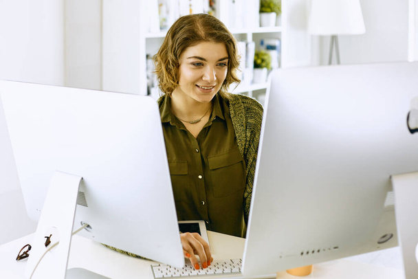 jonge vrouw die werkt met grafisch tablet in kantoor - Foto, afbeelding