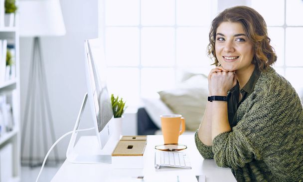 Young woman working with graphic tablet in office - Photo, image