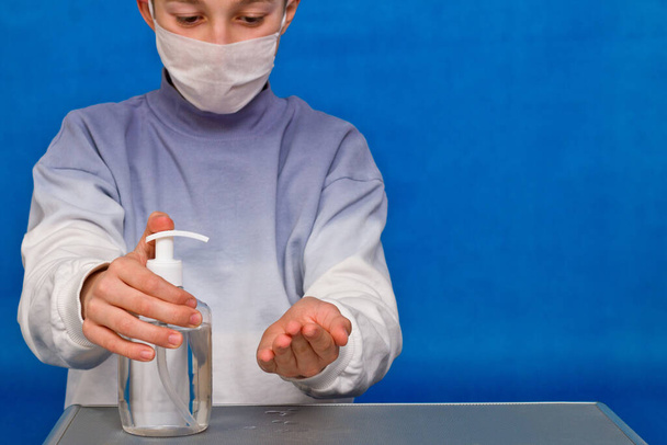 Młody facet dezynfekuje ręce środkiem dezynfekującym. Mycie rąk i higiena rąk podczas pandemii covi 19. - Zdjęcie, obraz