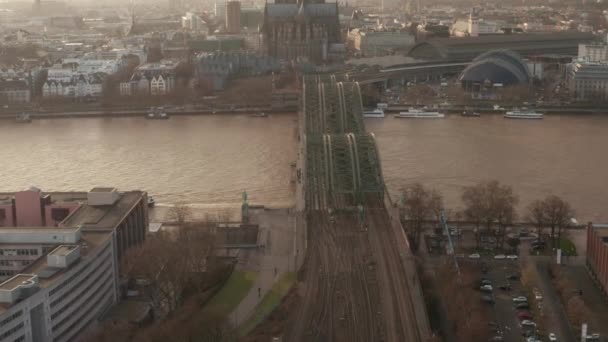 AERIAL: Θέα πάνω από τη γέφυρα και τον καθεδρικό ναό της Κολωνίας Hohenzollern στο όμορφο θολό φως του ήλιου  - Πλάνα, βίντεο