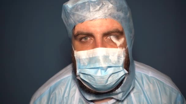 Vousatý lékař v ochranném obleku kontroluje laboratorní baňky na analýzu během pandemie koronaviru Covid-19. Unavený doktor v mlze. - Záběry, video
