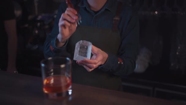 bartender preparing traditional old fashioned cocktail with whiskey and orange - Filmati, video