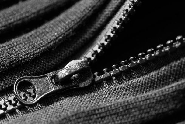 Black  plastic zipper on black knitted fabric. Close up. Macro. - Photo, Image