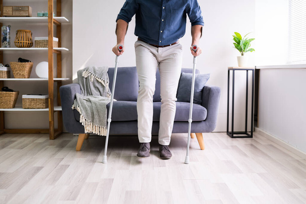 Disabled Man Using Crutches To Walk At Home - Foto, Imagen