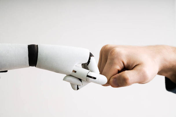 Robot And Human Hand Making Fist Bump On Grey Background - Foto, afbeelding