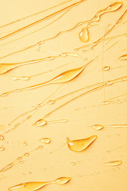 Background of melting honey on a yellow background, spreading honey place for text, drops, texture - Foto, imagen