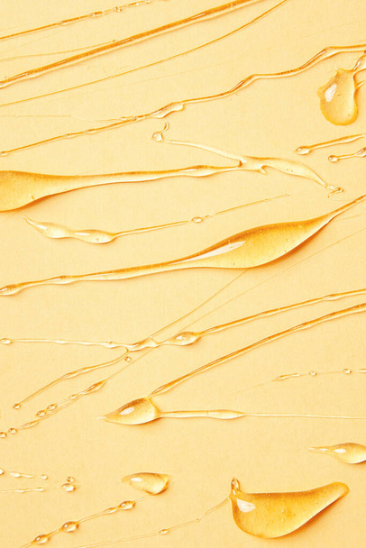 Background of melting honey on a yellow background, spreading honey place for text, drops, texture - Foto, imagen