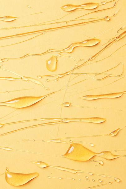 Background of melting honey on a yellow background, spreading honey place for text, drops, texture - Photo, image
