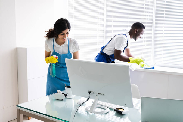 Young Male And Female Cleaners Cleaning Office - Fotoğraf, Görsel