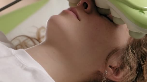 Bir kadın masaj yatağında yeşil bigudilerle yatıyor.. - Video, Çekim