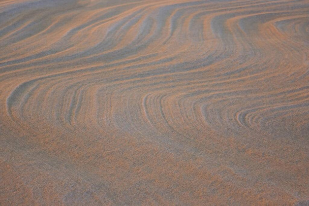 Cold desert, sand dunes. Wavy lines, abstraction. Beige, orange tones. Side lighting. - Photo, Image