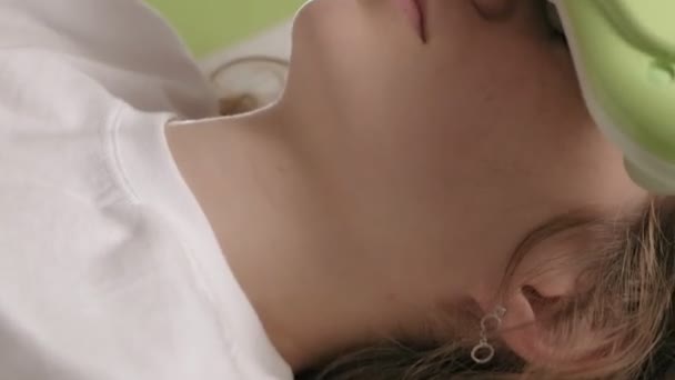 Une femme se couche sur un lit de massage avec des rouleaux de jade
. - Séquence, vidéo