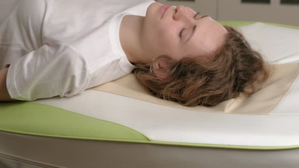 Uma mulher está em uma cama eletrônica de massagem
. - Filmagem, Vídeo