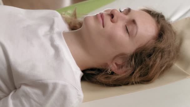 Eine Frau liegt auf einem Massagebett. - Filmmaterial, Video