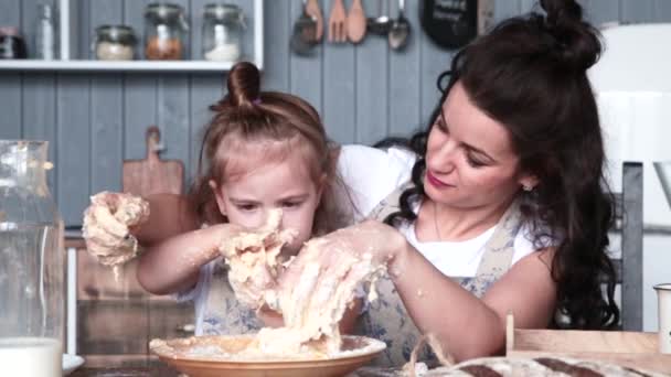 Mama i córka kolidują z ciastem w kuchni. Filmik o zwolnionym tempie - Materiał filmowy, wideo
