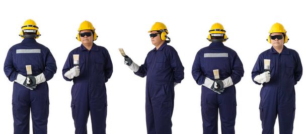 комплект полный портрет тела работника в механическом комбинезоне держит кисть краски с шлемом, наушниками, защитные перчатки и защитные очки изолированы на белом фоне клиппинга пути
 - Фото, изображение