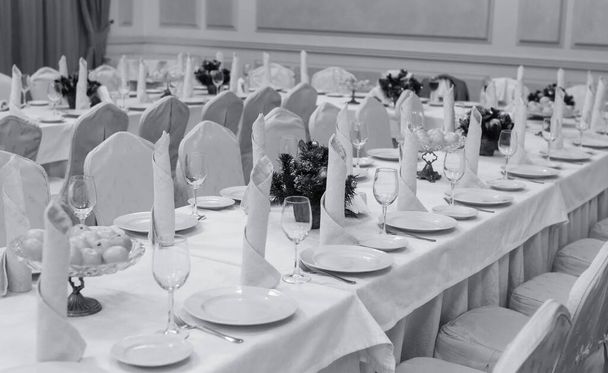 Apparecchiatura tavola festiva sfondo. Servire un grande tavolo da ristorante festivo in previsione degli ospiti in una luce soffusa
. - Foto, immagini